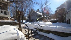 Un barrio residencial con escalones cubiertos de nieve que llevan a una casa.