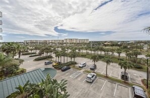 A parking lot with multiple cars, surrounded by palm trees and a large building in the background. - 7402 Towers 8 and 9 - 2/2 Oceanfront Beauty on Traffic Free Beach - Ponce Inlet (Ponce Inlet)