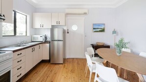 Eine moderne Küche mit weißen Schränken, Edelstahlgeräten und Holzboden.