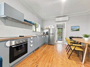 A modern kitchen with grey cabinets, a wooden countertop, and a built-in oven.