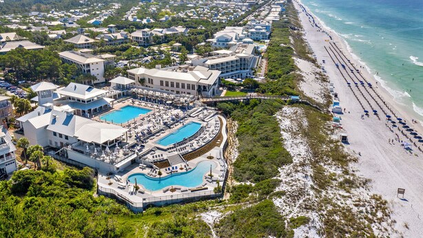 An aerial view of a resort with multiple swimming pools, beachfront access, and a long stretch of beach. - WaterColor "Yum" |1 BR | Sleeps 4| Camp District |2 Bikes (Santa Rosa Beach)