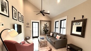 A living room with a red armchair, a grey sofa, a coffee table, and a ceiling fan. - WaterColor "Yum" |1 BR | Sleeps 4| Camp District |2 Bikes (Santa Rosa Beach)