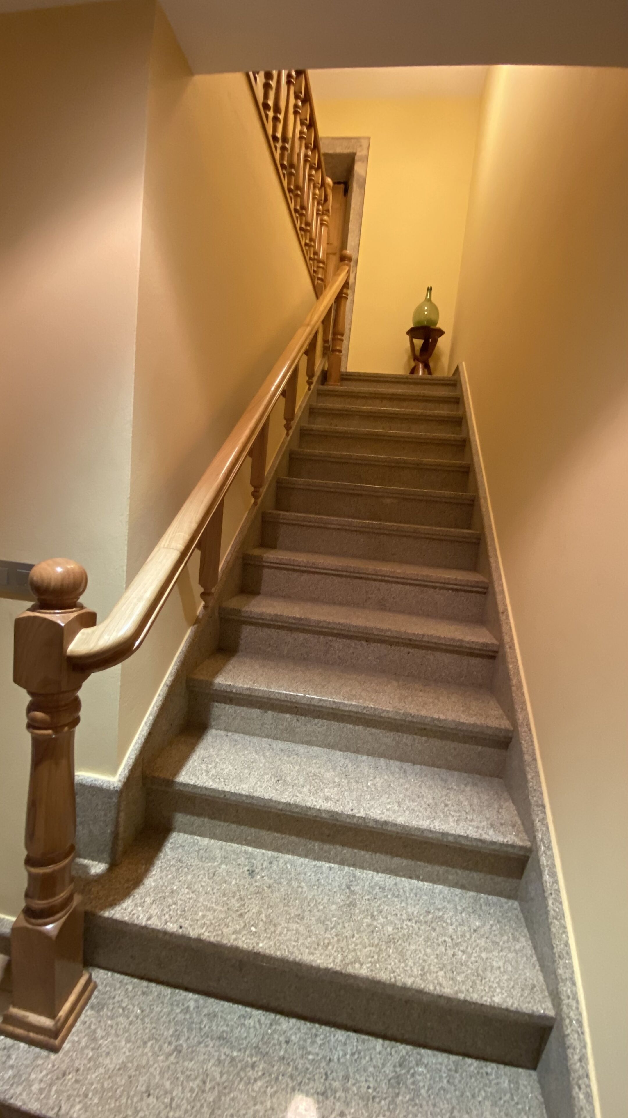 Eine Treppe mit hölzernen Geländern und Steinstufen.