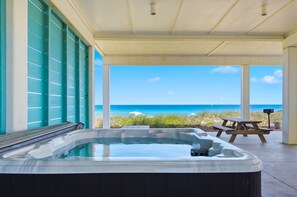 A hot tub with a view of the ocean, a wooden picnic table, and a covered patio area. - LET SALTY LANDING TAKE YOUR CARES AWAY! (St. George Island)
