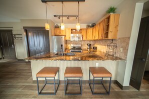 Enjoy cooking in this well-equipped kitchen with a central island, stainless steel appliances, and ample counter space.