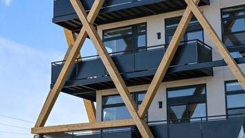 A multi-story building with a unique geometric facade, featuring balconies and large windows.