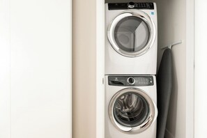 Vue de face d’un appareil combinant deux machines à laver, avec ses panneaux de commande.