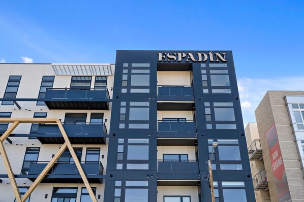 Un immeuble à plusieurs étages dont la façade porte en grand le nom « ESPADIN ».