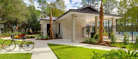 A modern house with a covered patio, a bicycle parked outside, and a well-maintained lawn.