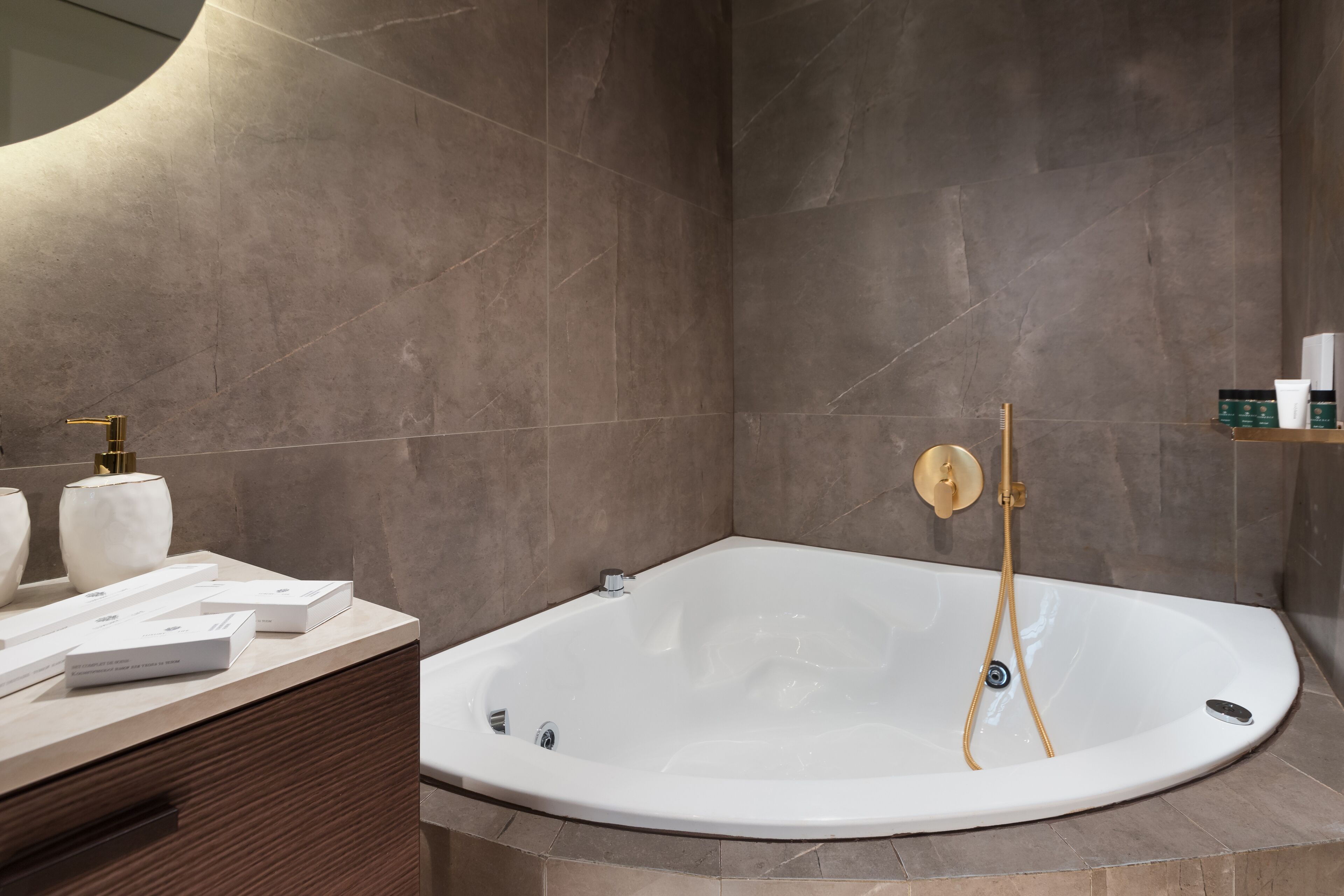 A modern bathroom with a freestanding bathtub, a vanity with toiletries, and a shower area.