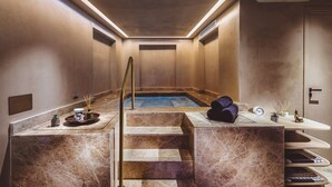 A spa area with a hot tub, marble steps, and a reception desk with amenities. - The Residence Aiolou Hotel & Spa (Athens)