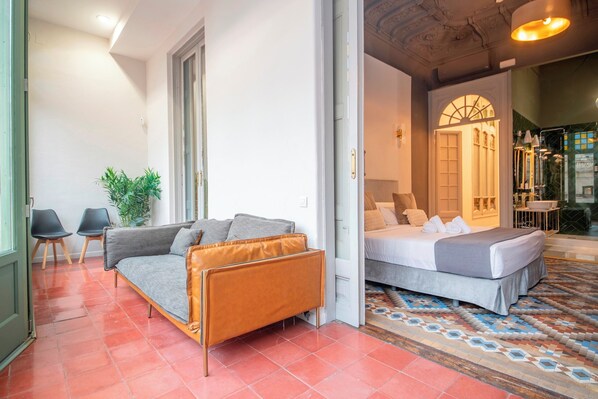 Un dormitorio moderno con una cama, un sofá y una pequeña mesa.