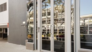 Entrada de un edificio con puertas de cristal y un cartel que dice 'The Media Centre'.