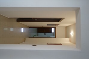 A modern, minimalist bathroom with a large mirror, a built-in sink, and a recessed ceiling light. - Don Mario House   (Ispica)