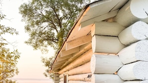 Una cabaña de troncos con fachada de madera, una ventana y una puerta.
