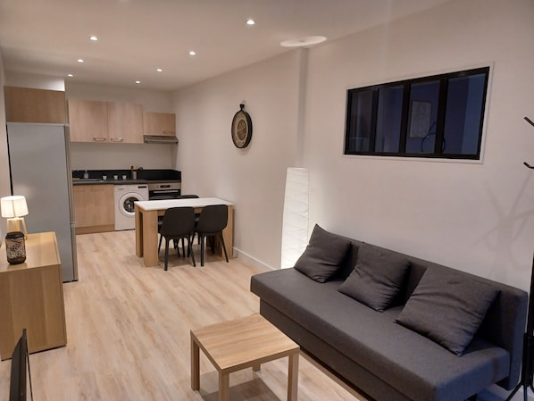 A modern apartment with a kitchen, dining area, and living room.