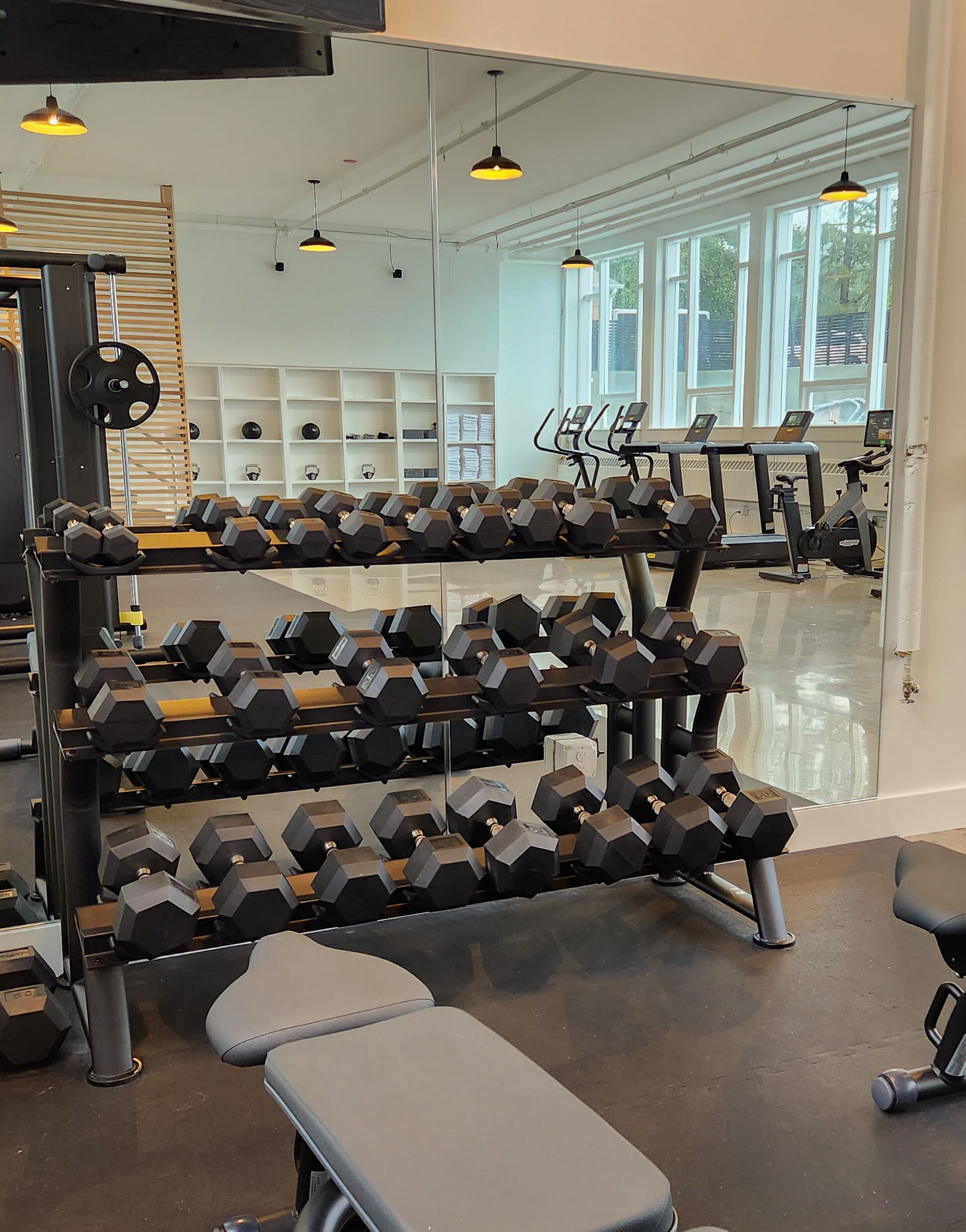 A gym with weight racks, treadmills, and exercise equipment.