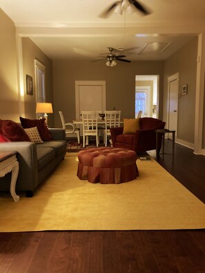 Relax in this inviting living room with a sofa, ottoman, and armchair, perfect for unwinding.