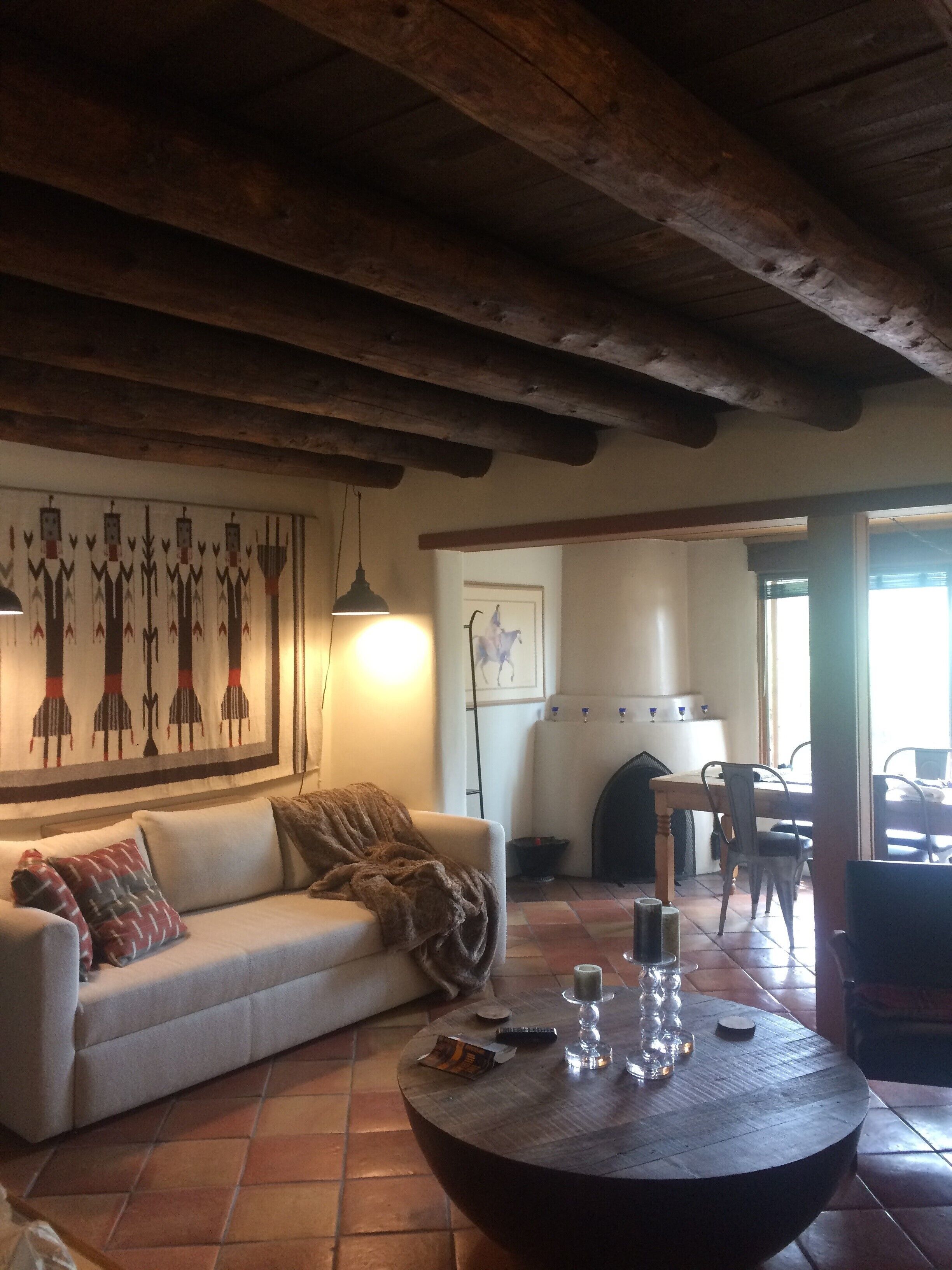 Una sala de estar acogedora con techo de madera, un sofá, una mesa de centro y una chimenea.