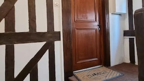 A wooden door with a doormat that reads "WELCOME".
