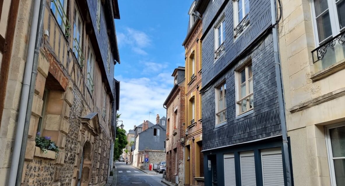 Une rue étroite bordée de bâtiments historiques, caractérisée par des façades en pierre et une architecture traditionnelle.
