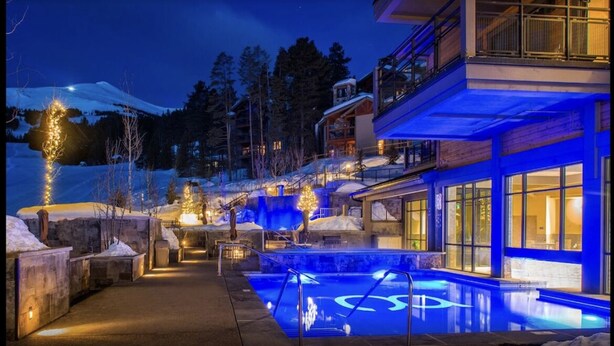 A modern hotel with a pool, snow-covered landscape, and illuminated trees. - Ski In - Ski Out, One-Bedroom Breckenridge Residence Peak 8, Corner unit (Breckenridge)
