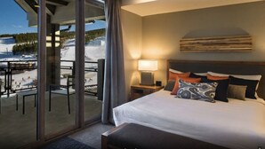 A hotel room with a large bed, a nightstand, a lamp, and a view of a snowy landscape through a glass door. - Ski In - Ski Out, One-Bedroom Breckenridge Residence Peak 8, Corner unit (Breckenridge)