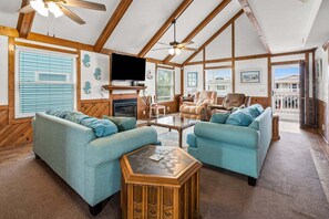 A spacious living room with a fireplace, two sofas, a coffee table, and a television.