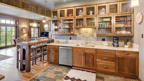 A spacious kitchen with wooden cabinets, a central island, and a dining area with a large table.