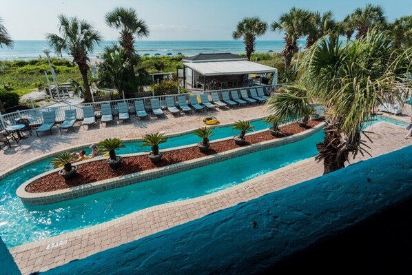 Relax by the oceanfront pool surrounded by palm trees and lounge chairs.