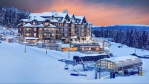 A large, multi-story lodge with a ski lift and snow-covered surroundings. - Ski In - Ski Out, Two-Bedroom Breckenridge Residence on Peak 8, Corner unit (Breckenridge)