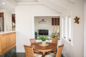 A dining area with a round table, chairs, and a potted plant. - Airlie Beach Seaviews (Airlie Beach)