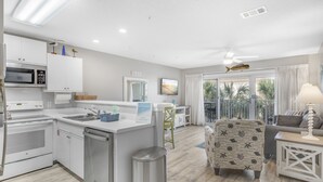 A modern kitchen with white cabinetry, a built-in microwave, and a dishwasher. - Pet-Friendly Maravilla Condo–Beach Ramp, Pools, Free Beach Setup, 1BDR + Bunks (Miramar Beach)