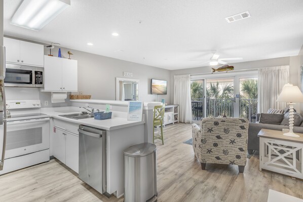 A modern kitchen with white cabinetry, a built-in microwave, and a dishwasher.