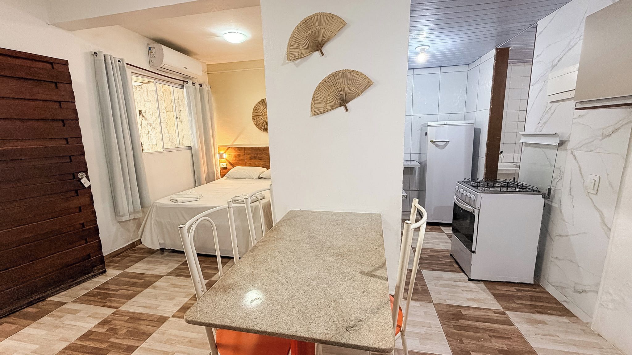 Una cuina compacta amb una taula de dinar, un frigorífic i una placa de cocció.