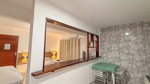Habitación de hotel con un espejo grande, una mesa pequeña con mantel a cuadros y una pared con diseño de mármol.