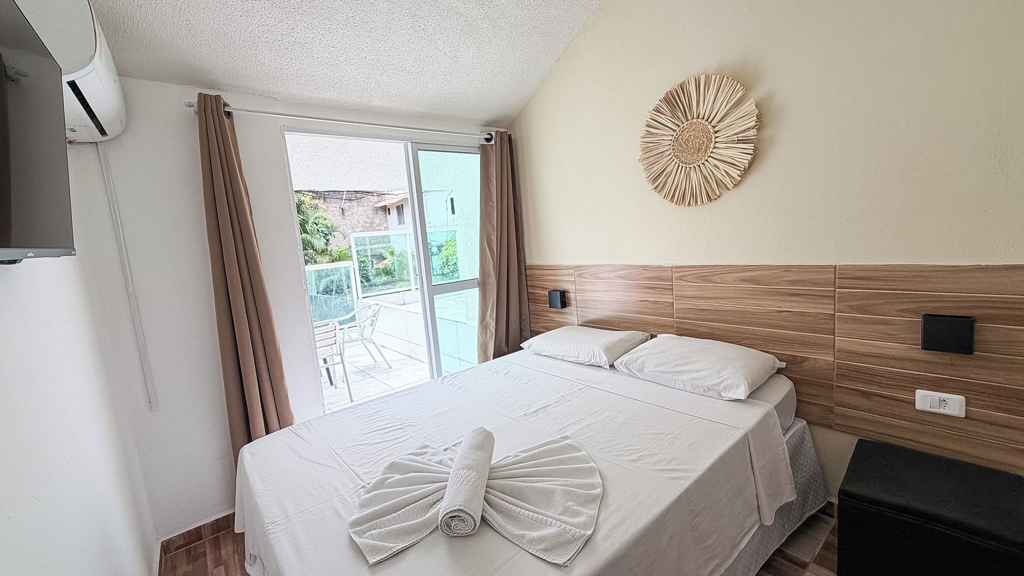Habitación de hotel con cama, un adorno en la pared y vistas al exterior.