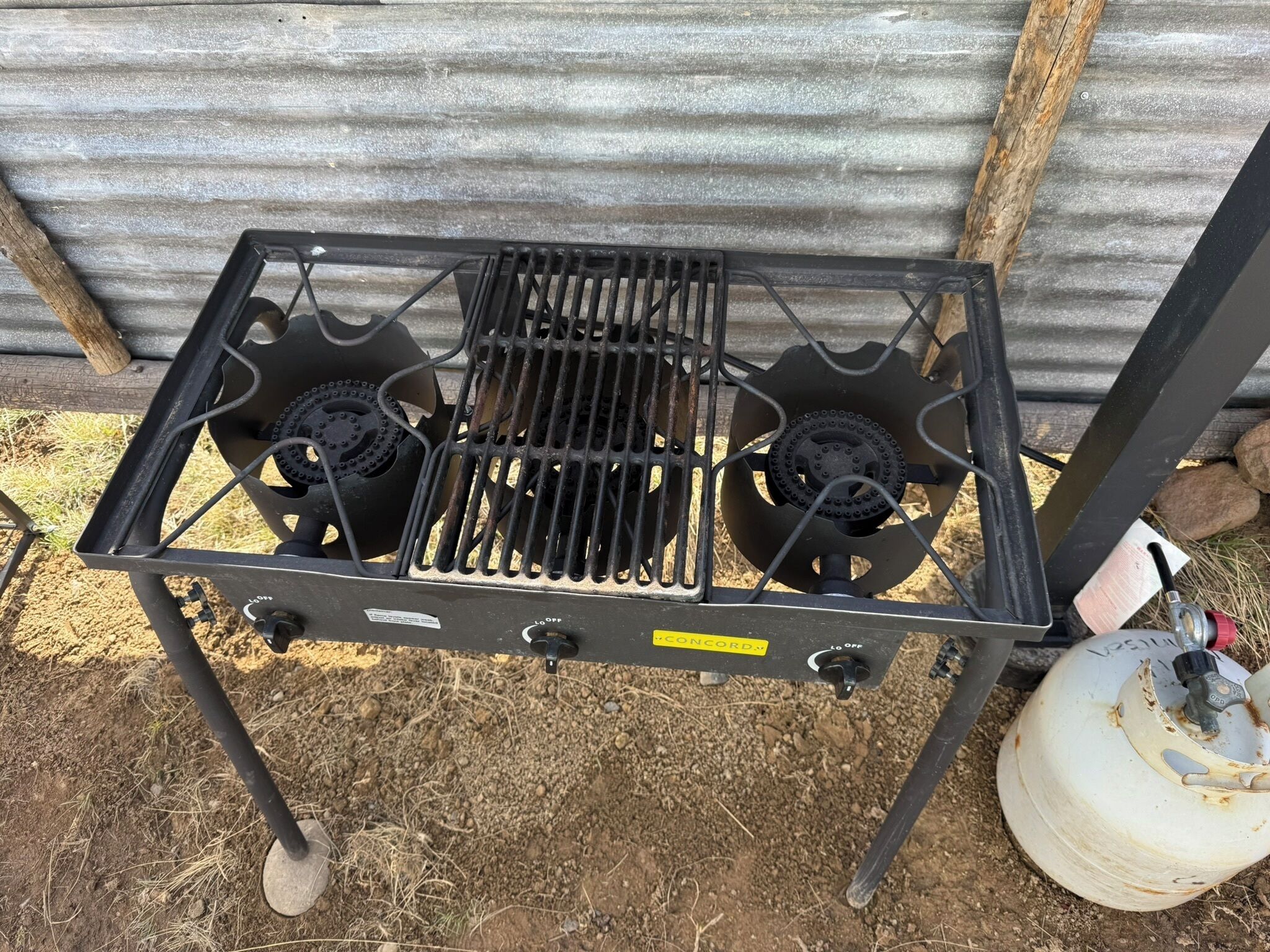 Une cuisinière à gaz portable dotée de deux brûleurs, d’un panneau de commande et d’une bouteille de gaz.