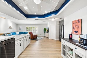 A modern kitchen with white cabinets, a wooden countertop, and a built-in oven.