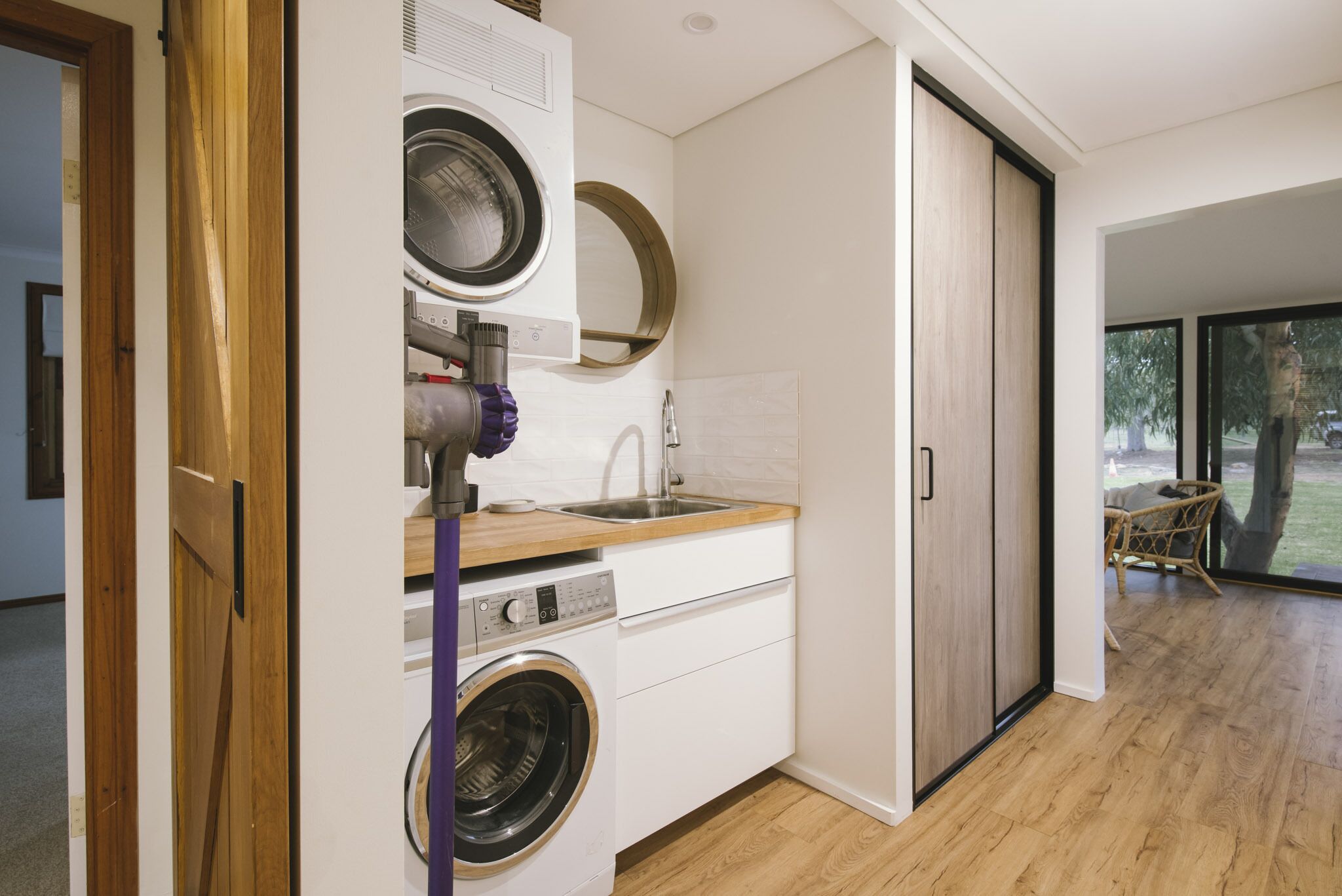 A compact kitchen with a washing machine, a sink, and a wooden countertop.