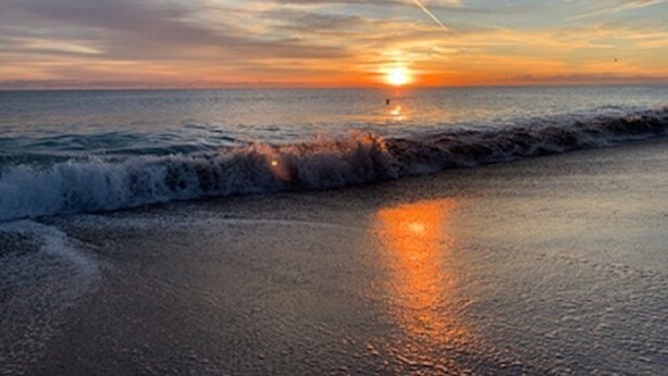 A sunset over the ocean with waves on a beach. - Flirt with the Flamingos in Beach Bliss ~Just Steps to the Sand (FORT PIERCE)