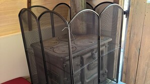 A room with a metal mesh partition, a wooden door, and a red bench. - Sheep Camp - Steel and Wool Rustic Hideaway (Collbran)