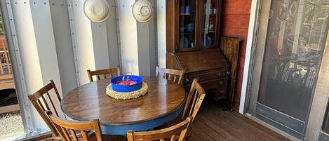 A wooden dining table with six chairs, a blue bowl, and a cabinet with glass doors.