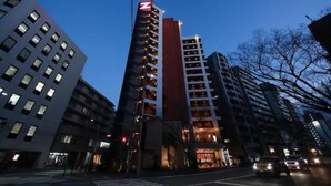 A multi-story hotel with a prominent red 'Z' logo on the facade, multiple balconies, and a ground-level entrance with illuminated signage. - ZONK HOTEL HAKATA (Fukuoka)