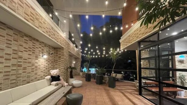 An outdoor seating area with brick walls, string lights, and potted plants. - ZONK HOTEL HAKATA (Fukuoka)