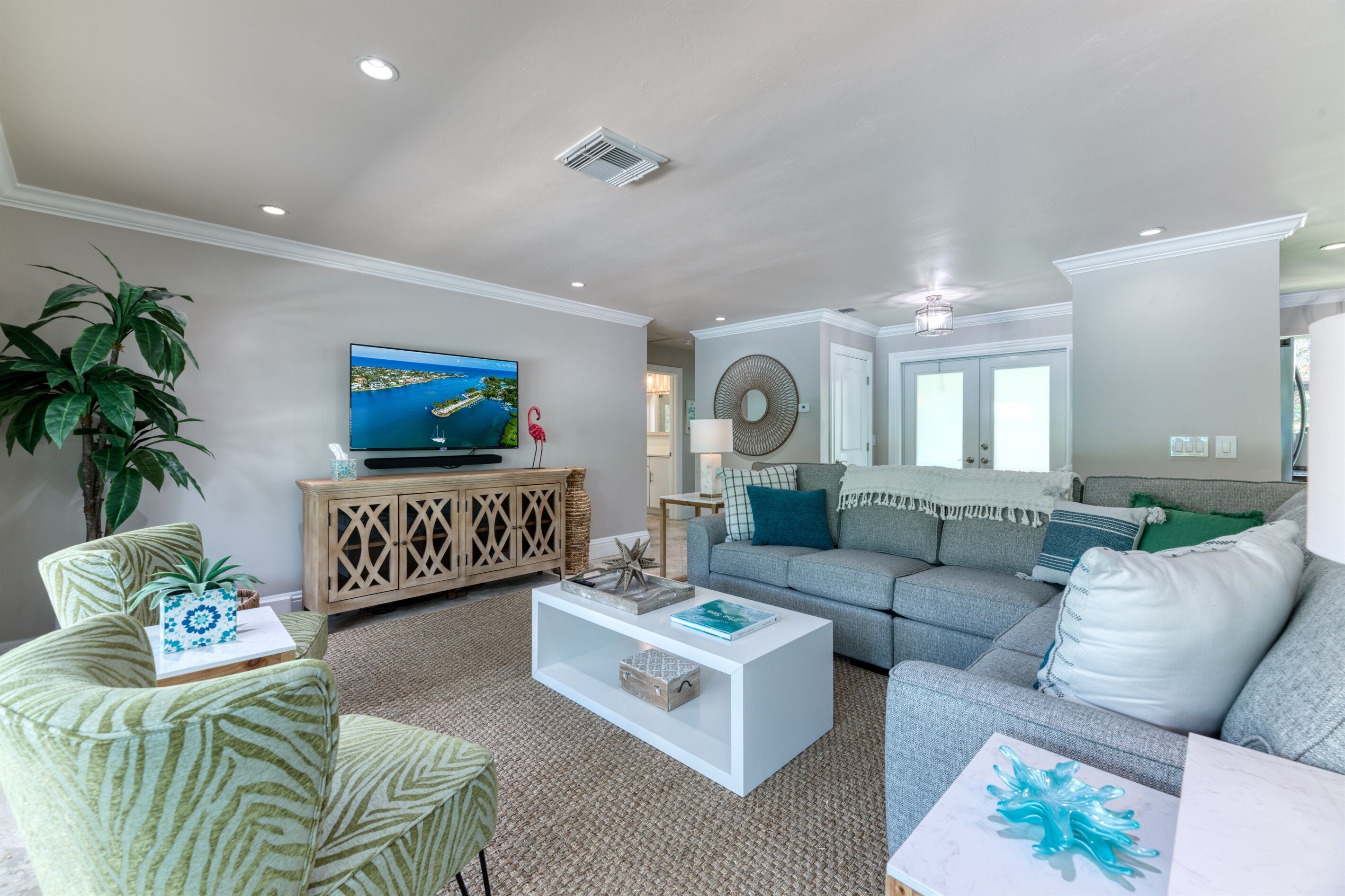 A living room with a television, a sofa, a coffee table, and a cabinet.