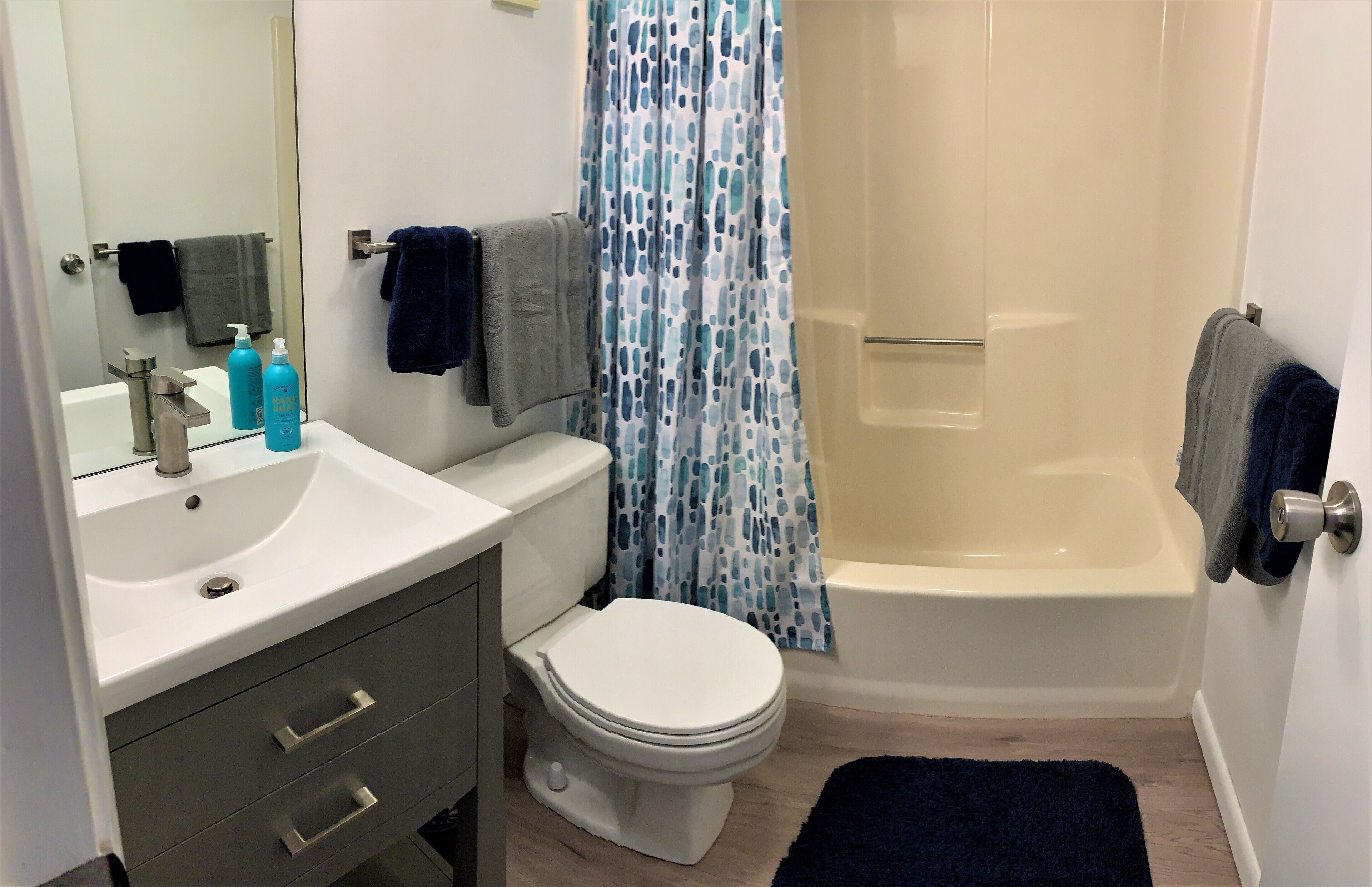 A bathroom with a white sink, a toilet, a bathtub, and a shower curtain.