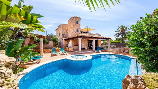 Una piscina con un edificio de piedra al fondo.