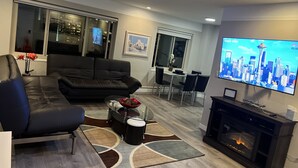 A modern living room with a black leather sofa, a glass coffee table, and a fireplace. - 2 bedroom penthouse downtown Seattle (Seattle)