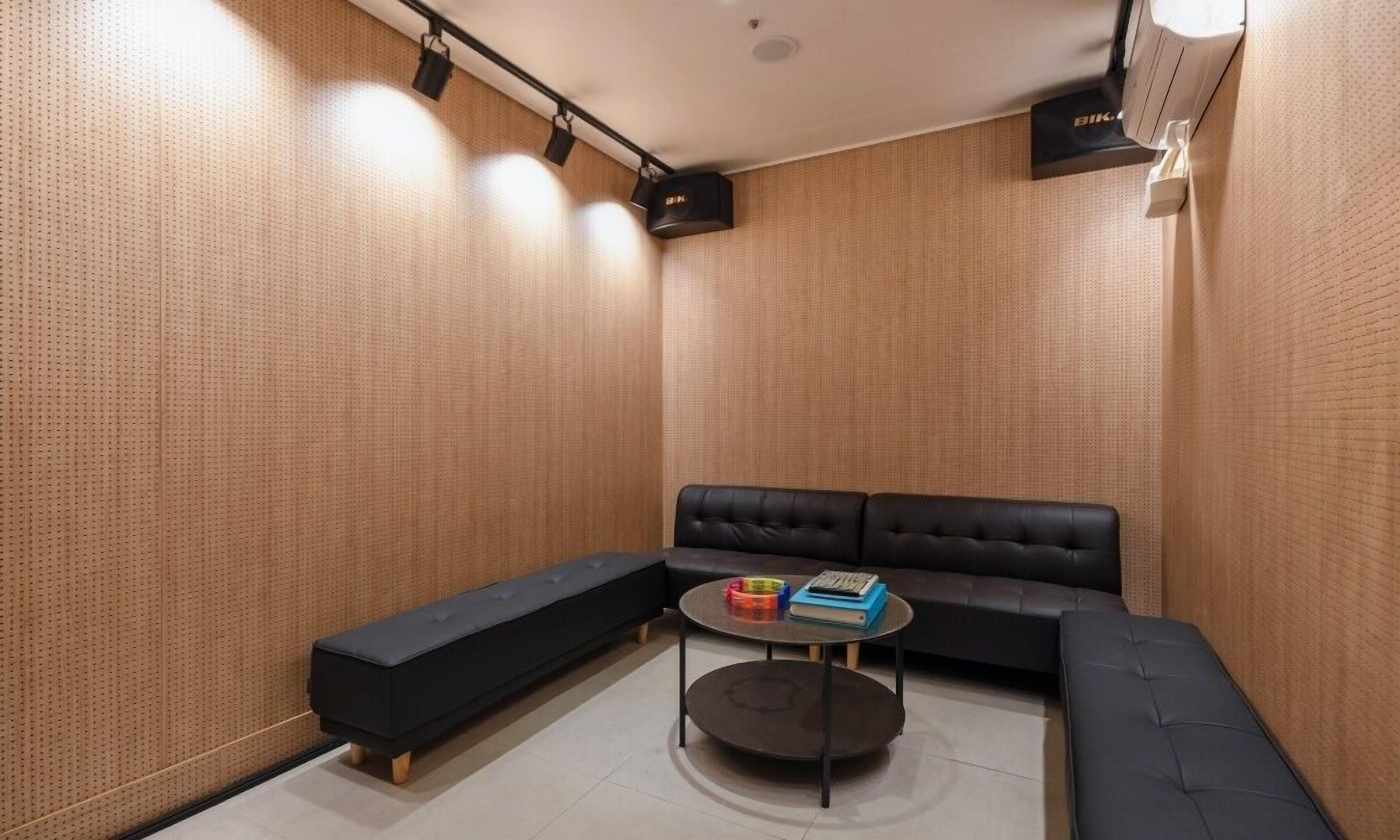 A modern, minimalist room with a black sofa, a black bench, and a round coffee table.